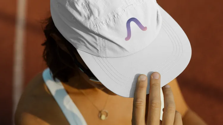 Bird’s-eye view of a sporty woman wearing a white cap with the Aeri app logo.
