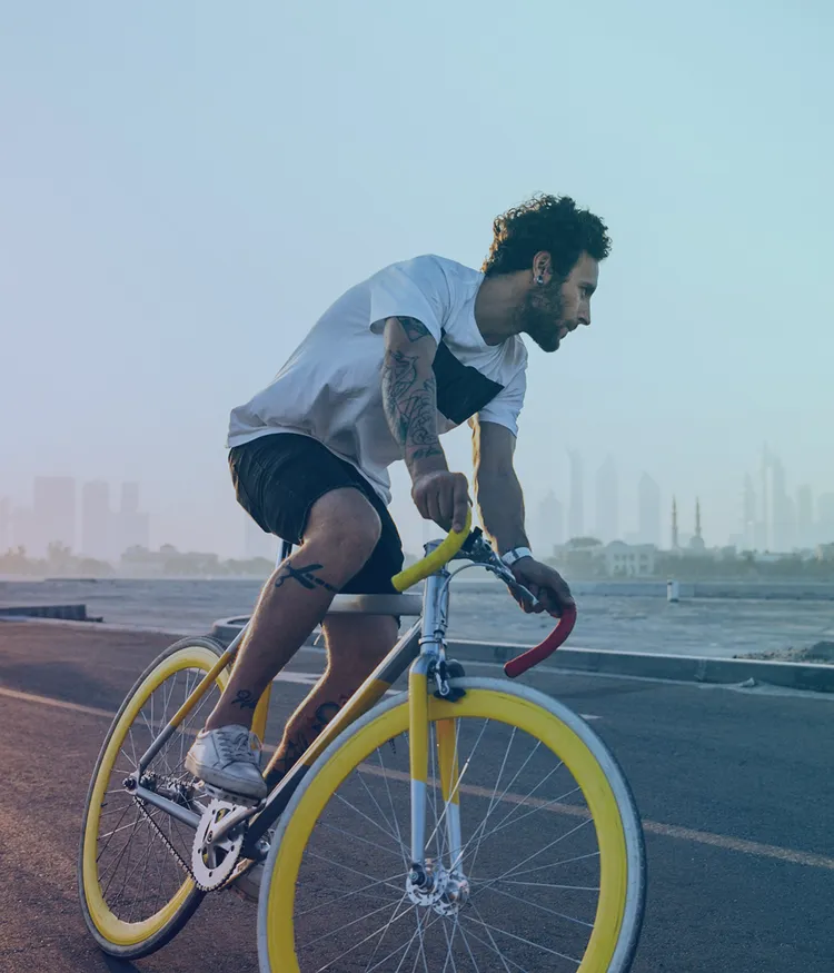 Cyclist on ocean road with skyline