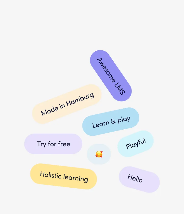 The image shows several colorful oval labels with different words and an emoji. The labels include the words: "Made in Hamburg", "Awesome LMS", "Try for free", "Holistic learning", "Learn & play", "Playful", and "Hello". In the center, there is a smiling emoji with a relaxed expression.