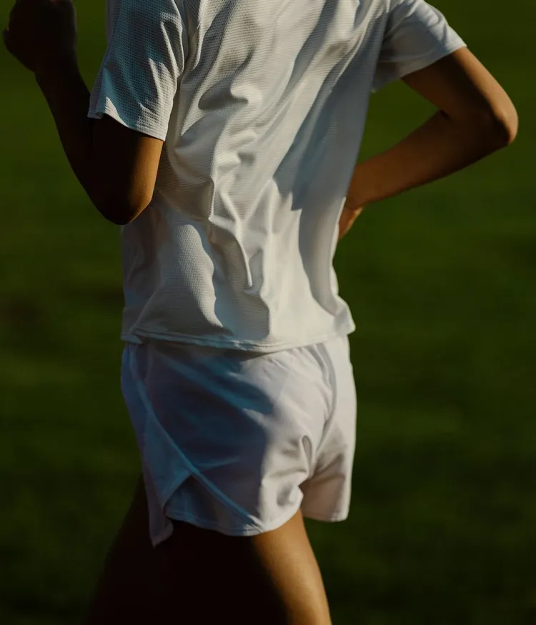 Dynamic close-up of a female runner from behind.