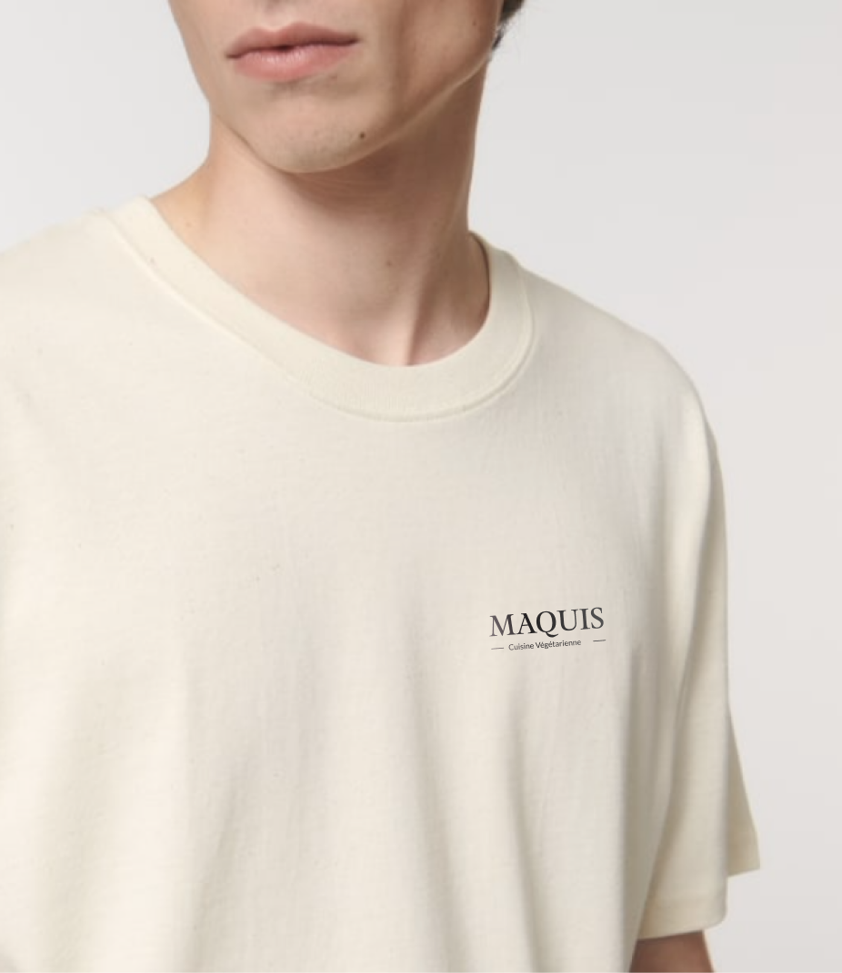 Detailaufnahme der Brust eines Mannes der ein beiges T-Shirt mit schwarzem Maquis-Logo trägt