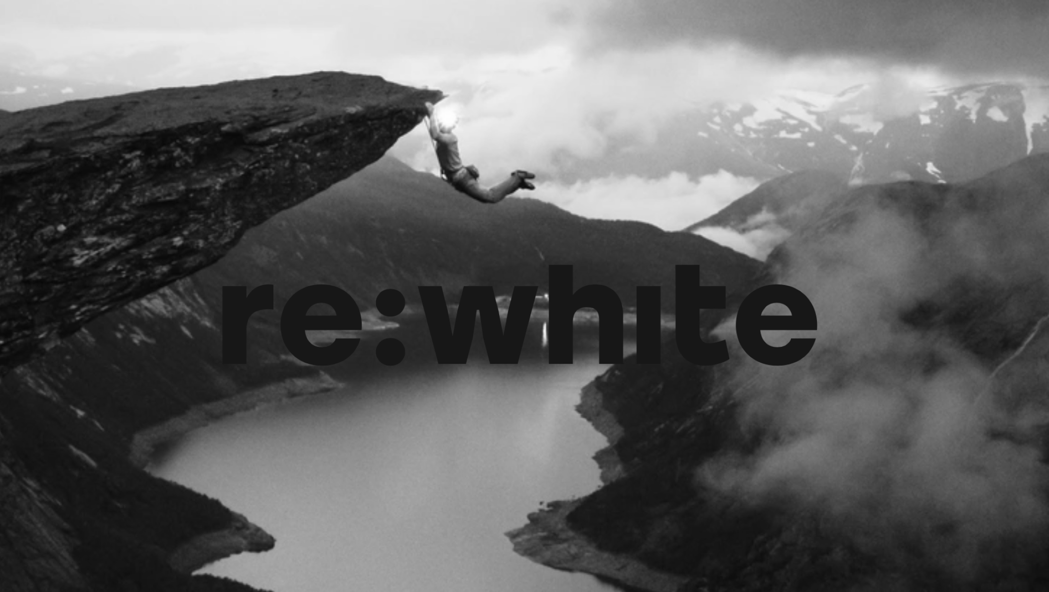 A man precariously hangs from a cliff, with the word "re:white" prominently displayed in the image.