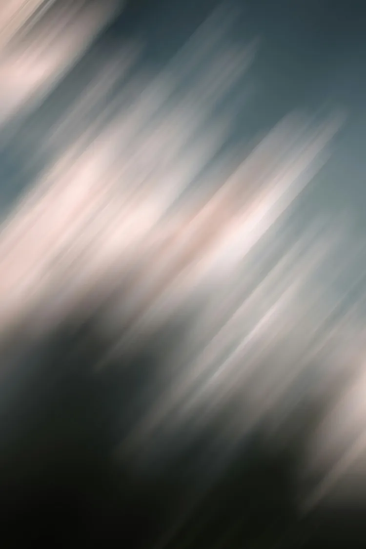 Abstract image with diagonal, blurred lines in shades of white, pink, and blue.